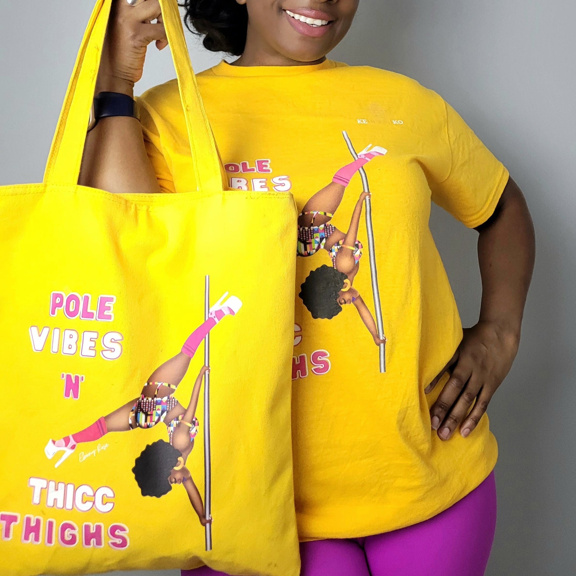 Yellow unisex t-shirt  featuring a black pole dancer wearing bright African inspired Afrocentric garter pole shorts and sports top. Bright pink knee socks and clear platform heels in an extended butterfly pole pose with slogan affirmation pole vibes n thicc vibes