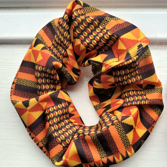 Large hair scrunchie ideal for black girls hair.  A bright vibrant hair bobble in African inspired modern Kente print featuring a bright blue, pink, yellow and purple colour pallet ideal for thick hair including dreadlocks and braids